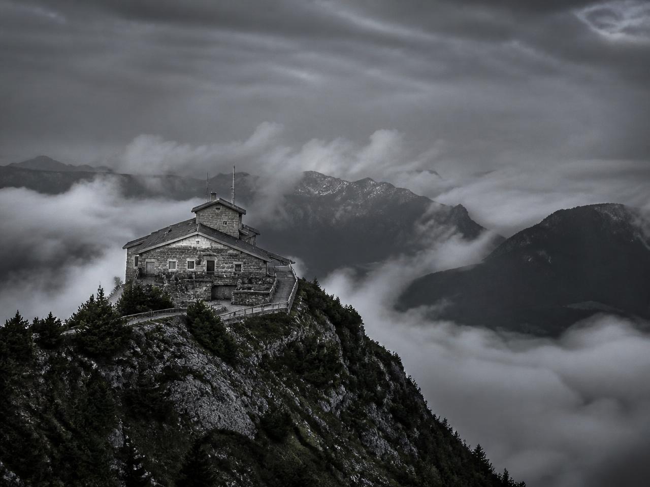 Mountain lodge above clouds in the Bavarian Alps